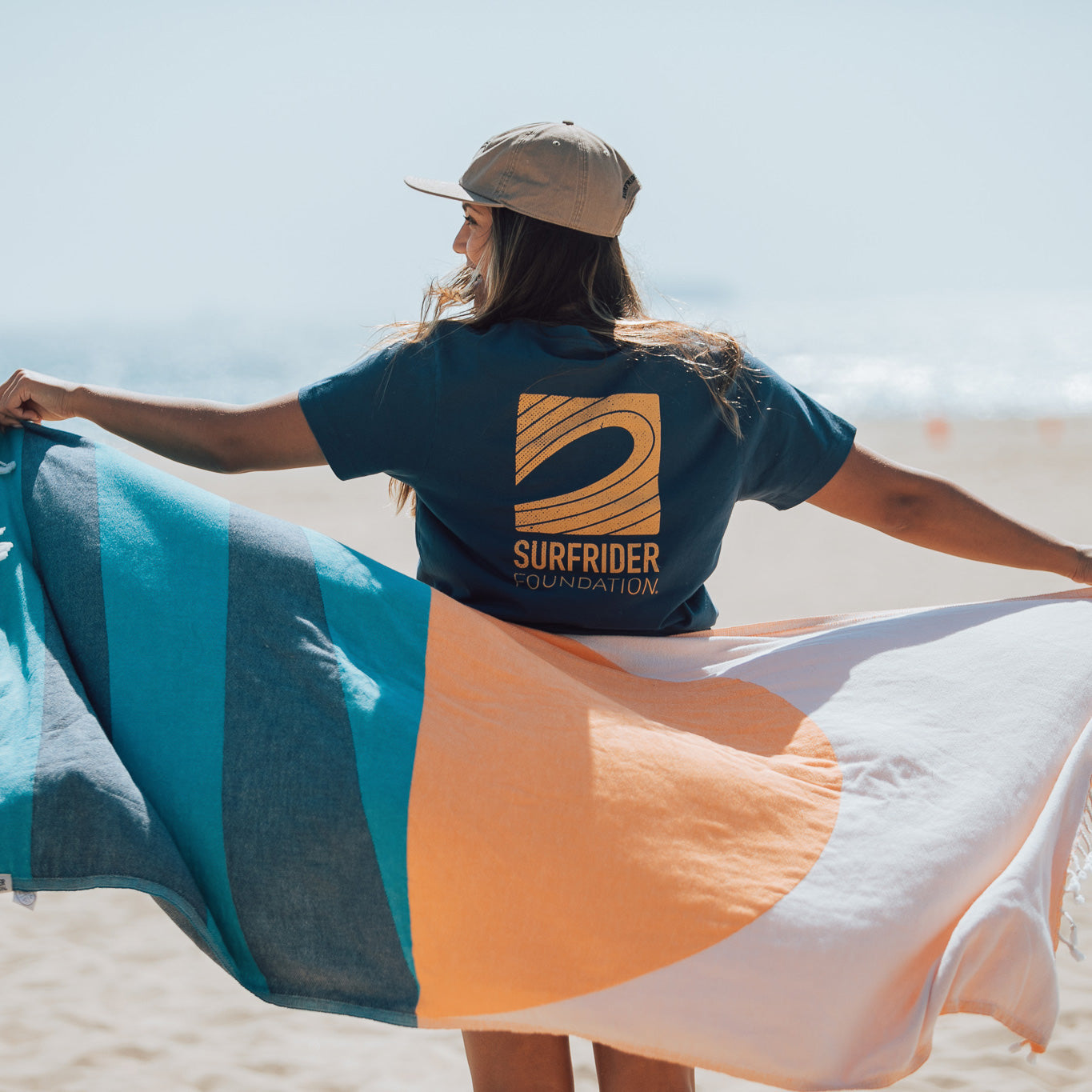 Back view of tee on a model at the beach. 